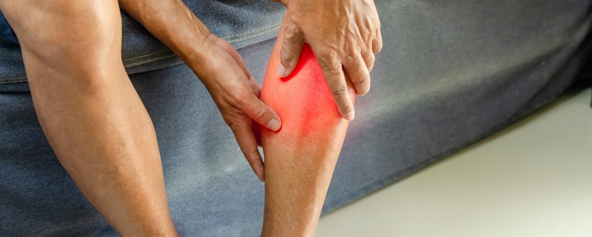 Injury or knee pain of an elderly man on the sofa.